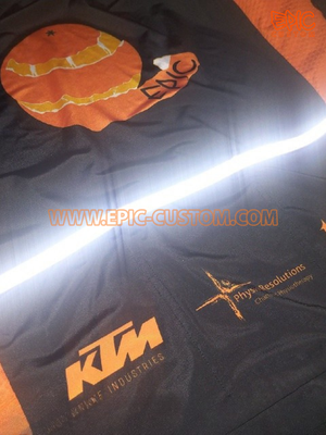 Custom printed cycle jersey reflective pocket trim illuminated for enhanced low-light visibility.