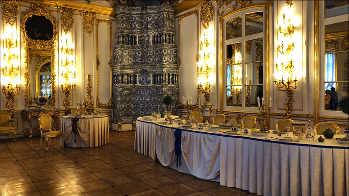 «Pushkin» '18 | Katharinenpalast: «Nachgedeckte» Tafel der Zarenfamilie. Einer der unzähligen, herrlichen Porzellan-Kachelöfen im Palast.