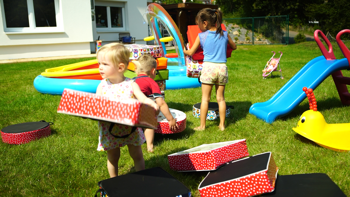 Kind spielt mit Sitzerhöhungen für draußen