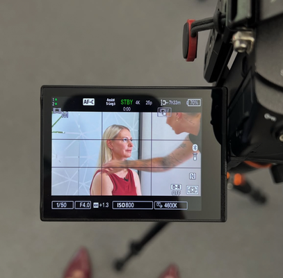 Blick durch Kamera auf Model – Business Make-up & Hairstyling für Fotoshootings und Filmproduktionen