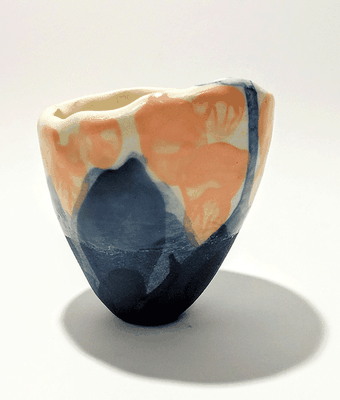 This unique yunomi is handmade in "Jasmin" earthenware using the "pinching" technique. The native colour of the material is a gentle creamy white. The yunomi is coloured with cobalt blue/black copper oxide underglaze and soft orange underglaze.