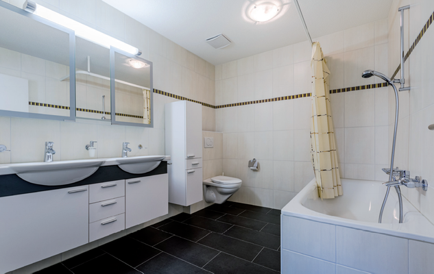 grosses Bad mit Badewanne/Dusche, Doppel-Lavabo und WC