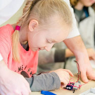Kind spielt mit einem MINT-Roboter