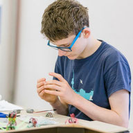 Schüler tüftelt an einem Roboter-Bausatz