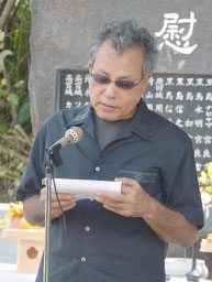 「戦争で逝った弟と妹に」と題して読み上げた宮良正之さん=3日、慰霊碑前