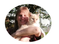 Silvia hält lächelnd ihre weiße Katze im Arm. Baum mit Blätter im Hintergrund.
