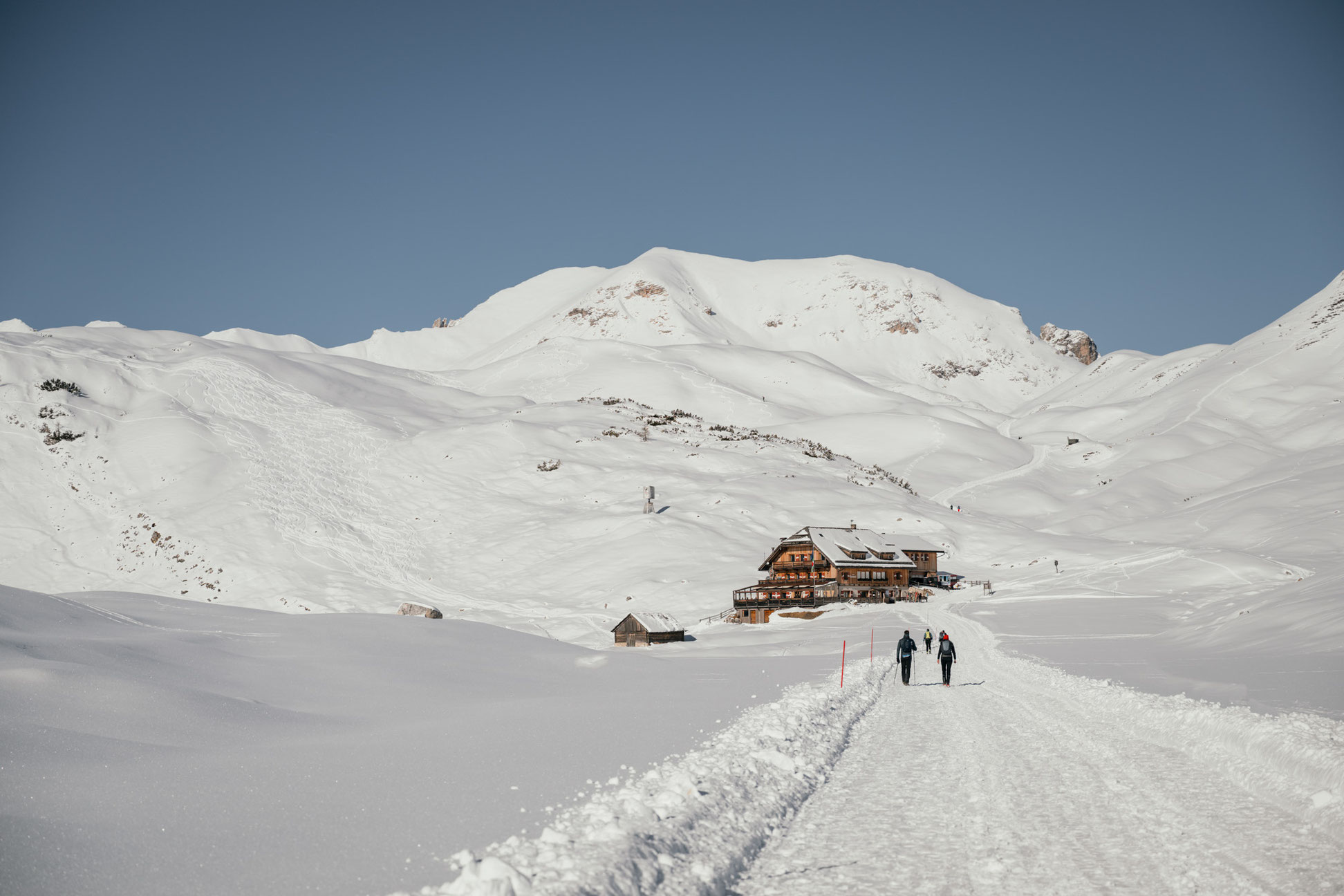 Präparierter Winterwanderweg auf den letzten Metern zur Sennes-Hütte im Naturpark Fanes-Sennes-Prags, umgeben von verschneiter Hochfläche. ©Marika Unterladstätter