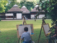 Kinder zeichnen das Spielhaus im Sommer