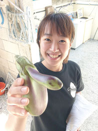 まるで天狗のような形のナスを持つ緑川さん=23日、竹富島