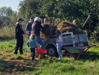 Die Kids der NAJU, Eltern und unsere Freiwilligen schichten das Mahdgut