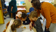 Die Kindergartenkinder schauen sich interessiert den Ordner an