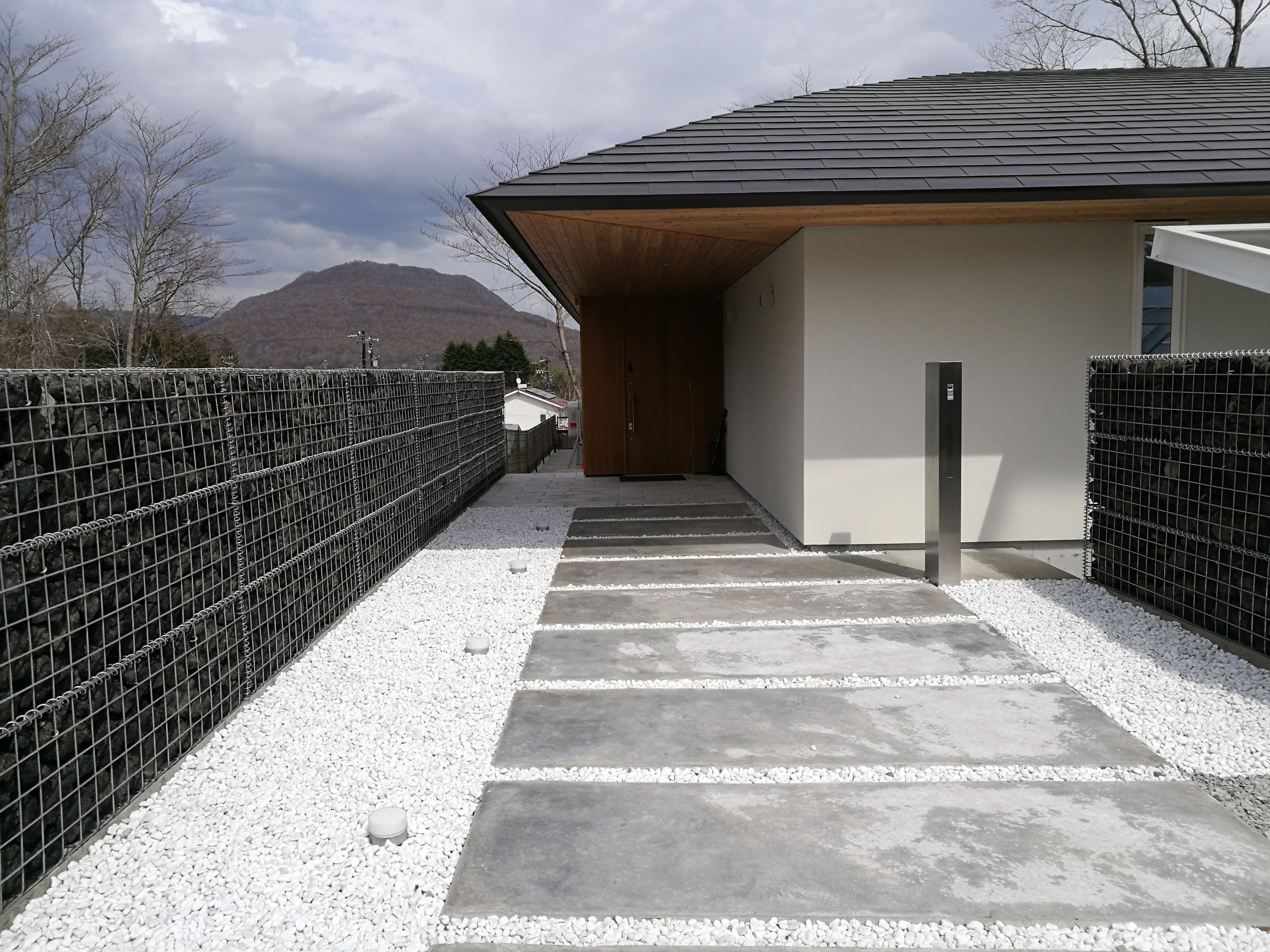 箱抜きされたコンクリート土間アプローチと白玉砂利施工｜軽井沢町内