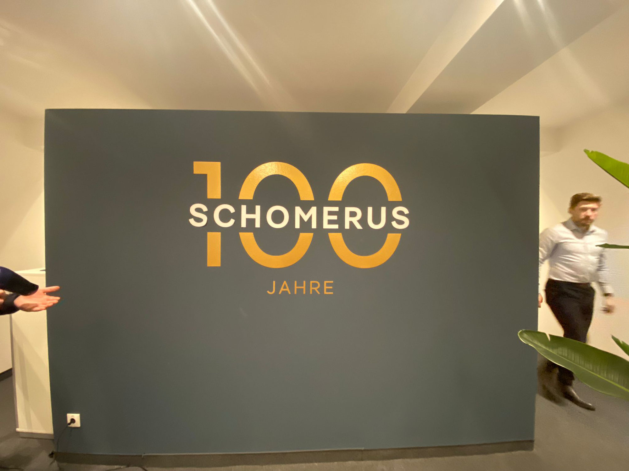 Edles Jubiläumsdesign mit Folienplot an der Wand – SCHOMERUS feiert 100 Jahre! Klebefolie Hamburg sorgt für beeindruckende Optik und saubere Umsetzung auf struk