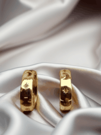 MOKOŠEV luxury jewelry, gold rings with delicate engraved symbols on glossy white satin.
