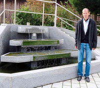 Wasser ist das lebensspendende Element schlechthin und es begleitet das christliche Leben. Kaplan Matthias Meckel hat den Brunnen vor der Geiganter Kirche St. Bartholomäus, eine seiner Wirkungsstätten, bewusst für das Foto gewählt. 