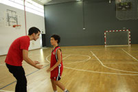 Javi, entrenador del Pre-mini, parlant amb un dels seus jugadors durant el seu partit a casa.