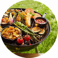 Kleiner Grill mit Spargel und Gemüse auf einer Wiese rund 2025