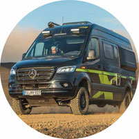 Camper Van in grau steht am Meer 2025