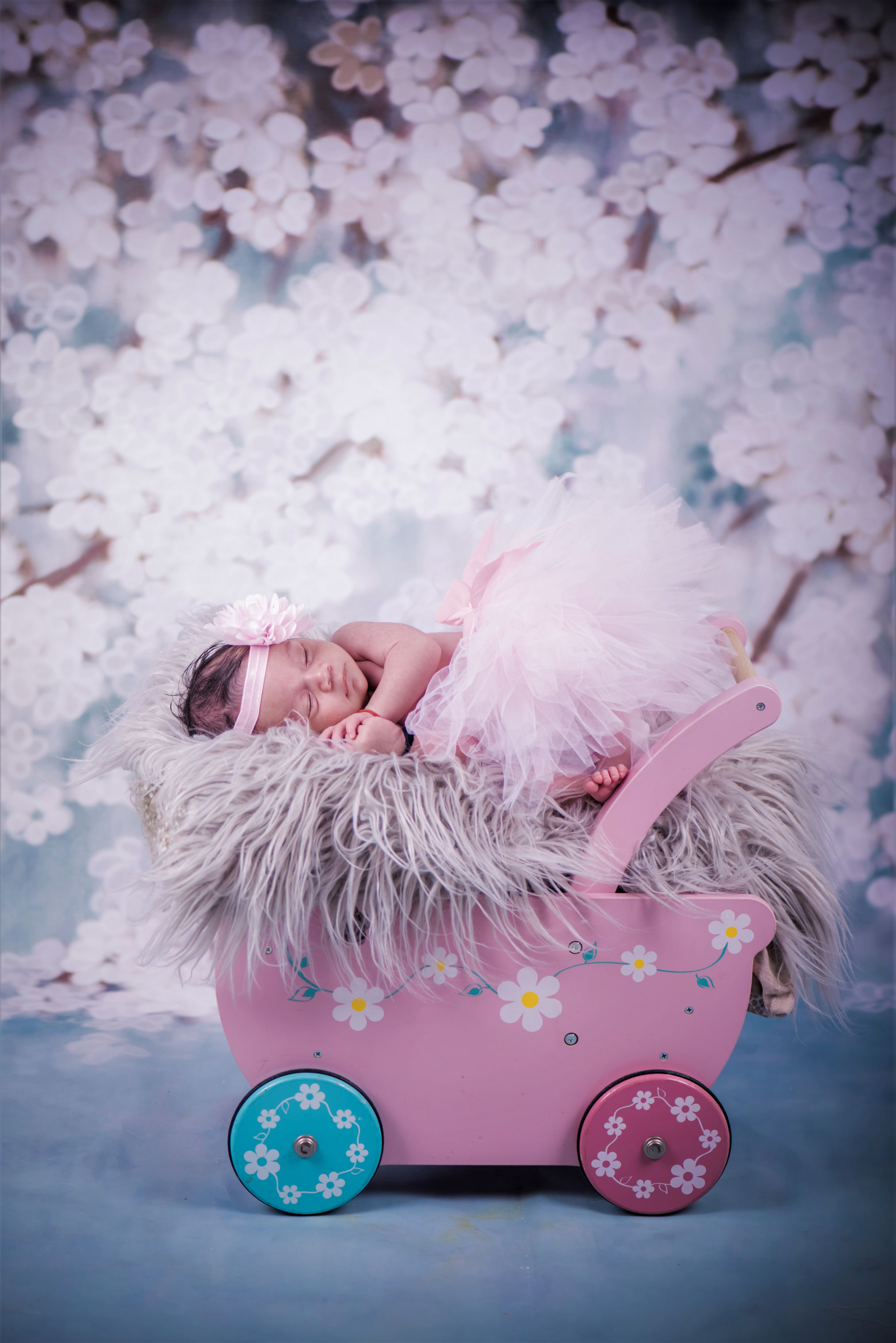 Newbornshoot van meisje in jurk in kinderwagen