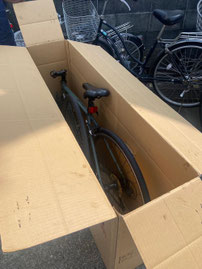 前輪とハンドルとペダルを外してダンボールに入れた自転車