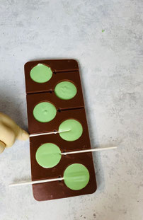Schokolade in die Silikonform füllen und Lolli - Stäbe einsetzen