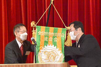 　次回幹事組合大阪（右）への大会旗授与