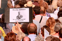 protestor holding a sign saying Benito Johnson leader of a fascist government