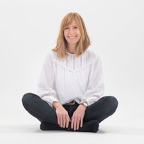 Imke Guzewski sitzt im Schneidersitz und wirkt entspannt und kompetent als Familienberaterin