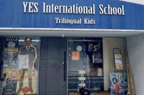 YESの外観。青の湾曲した看板に「YES International School」と書いてある。