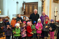 Die Kinder freuten sich über Weihnachtsgebäck, hinten Pfarrer Raimund Arnold und Richard Waldmann (v.r.). 