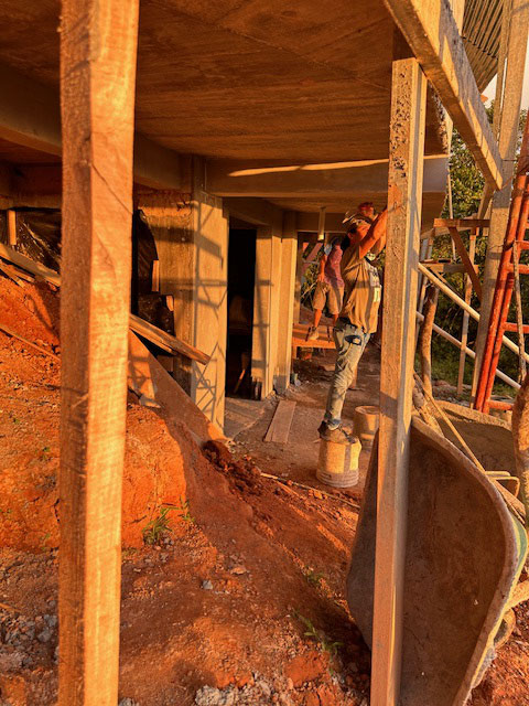 December 2023 - plastering the walls in the tech building below the pool at sunset; the guys work 6am to 6pm