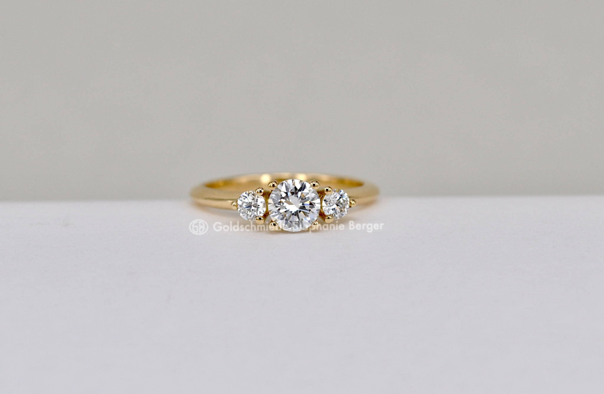 Trilogie Verlobungsring aus Gelbgold mit drei Brillanten, insgesamt 0,71 ct, elegantes und zeitloses Design als Symbol für Vergangenheit, Gegenwart und Zukunft.