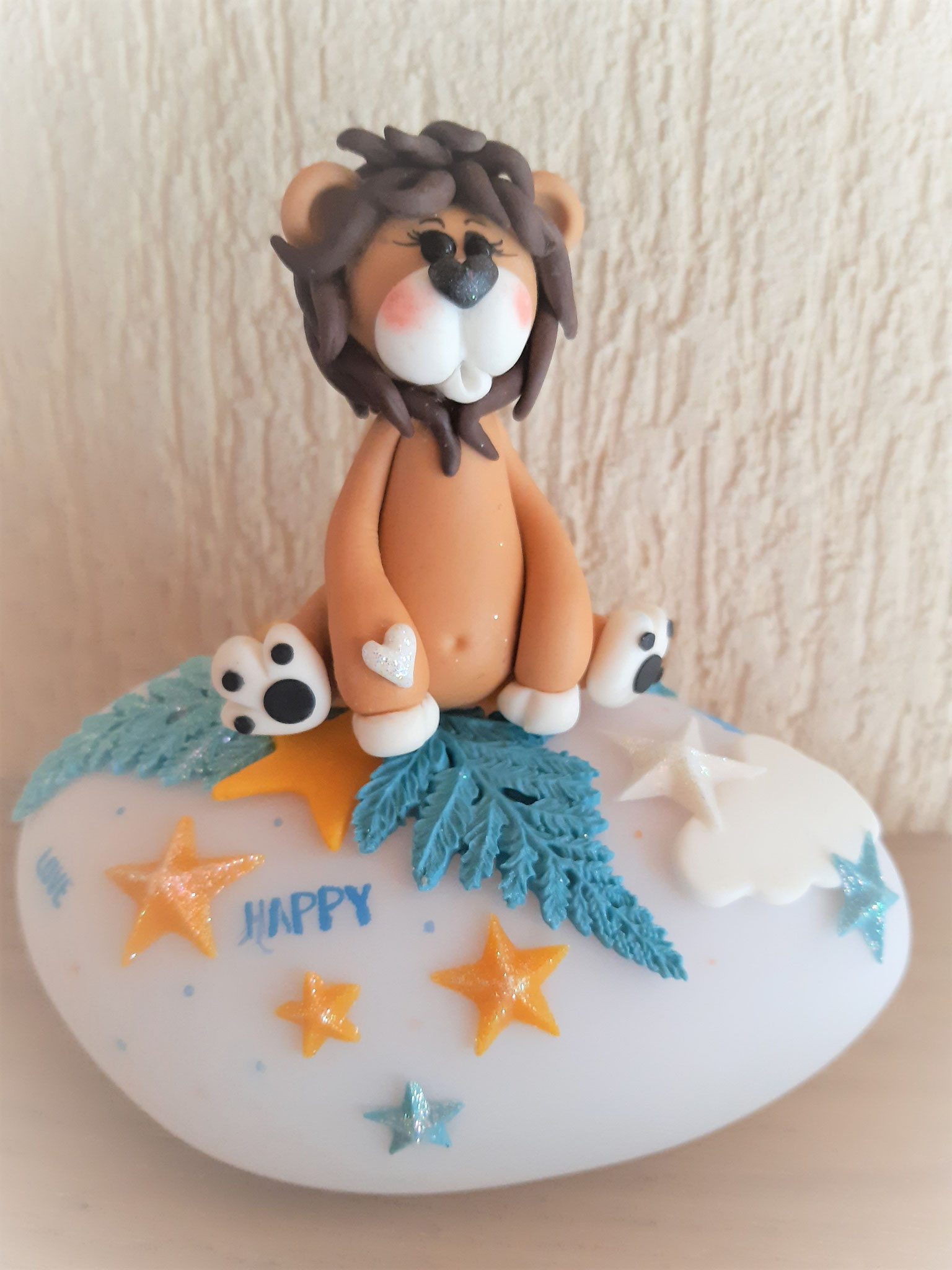 un joli petit lion sur un galet multi couleurs pour un p'tit héros aventurier