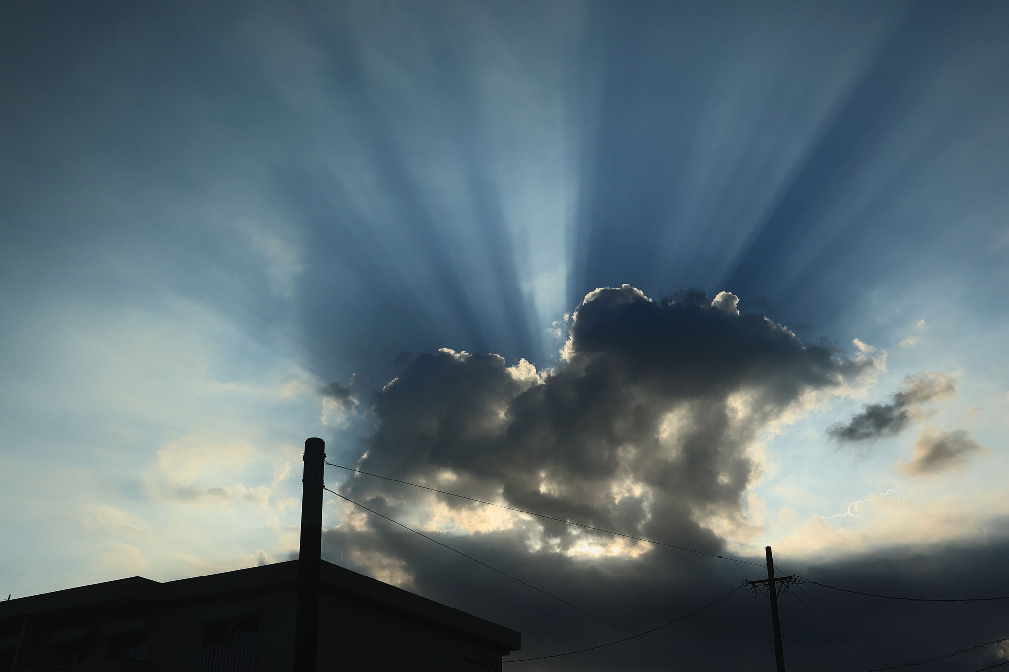 雲からいくつもの光が漏れ出る(7月21日 志布志市)