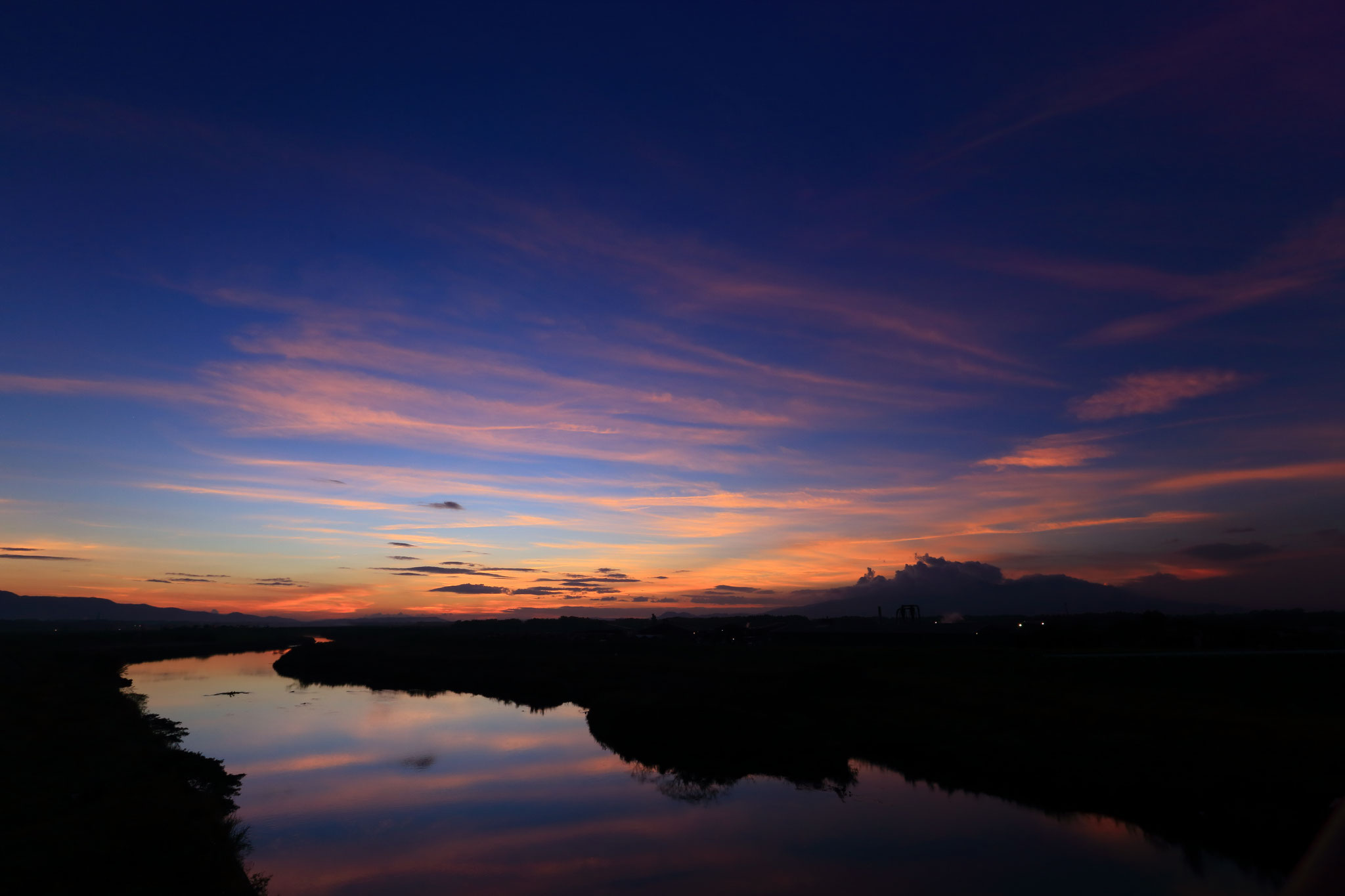 夕空が水面に写り幻想的な風景を見せる（高良橋）