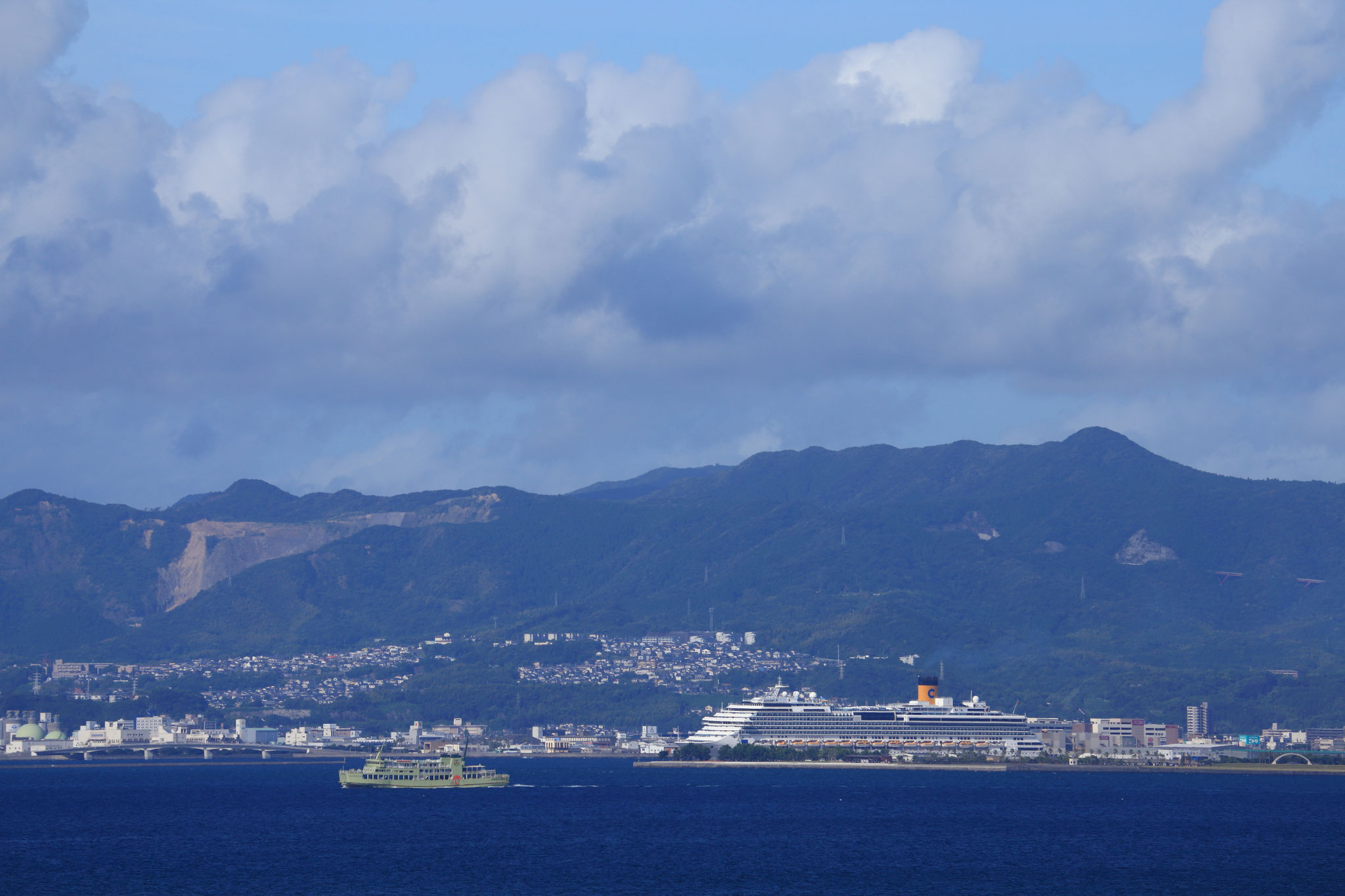 大型旅客船と比べるとフェリーが小さく見える(8/13 桜島町から撮影)