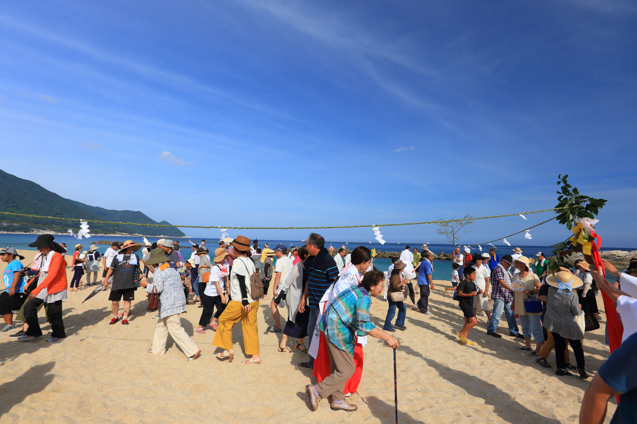 ナゴシドンにてチガヤのしめ縄くぐりで無病息災祈る（8/14 岸良海岸)