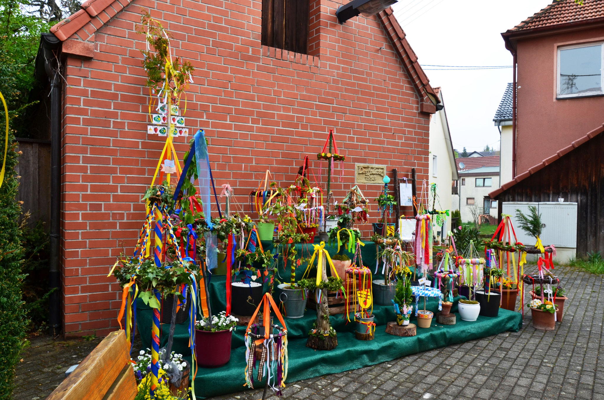 Mini-Maibäumchenwald schmückt den Dorfplatz Breuningsweiler