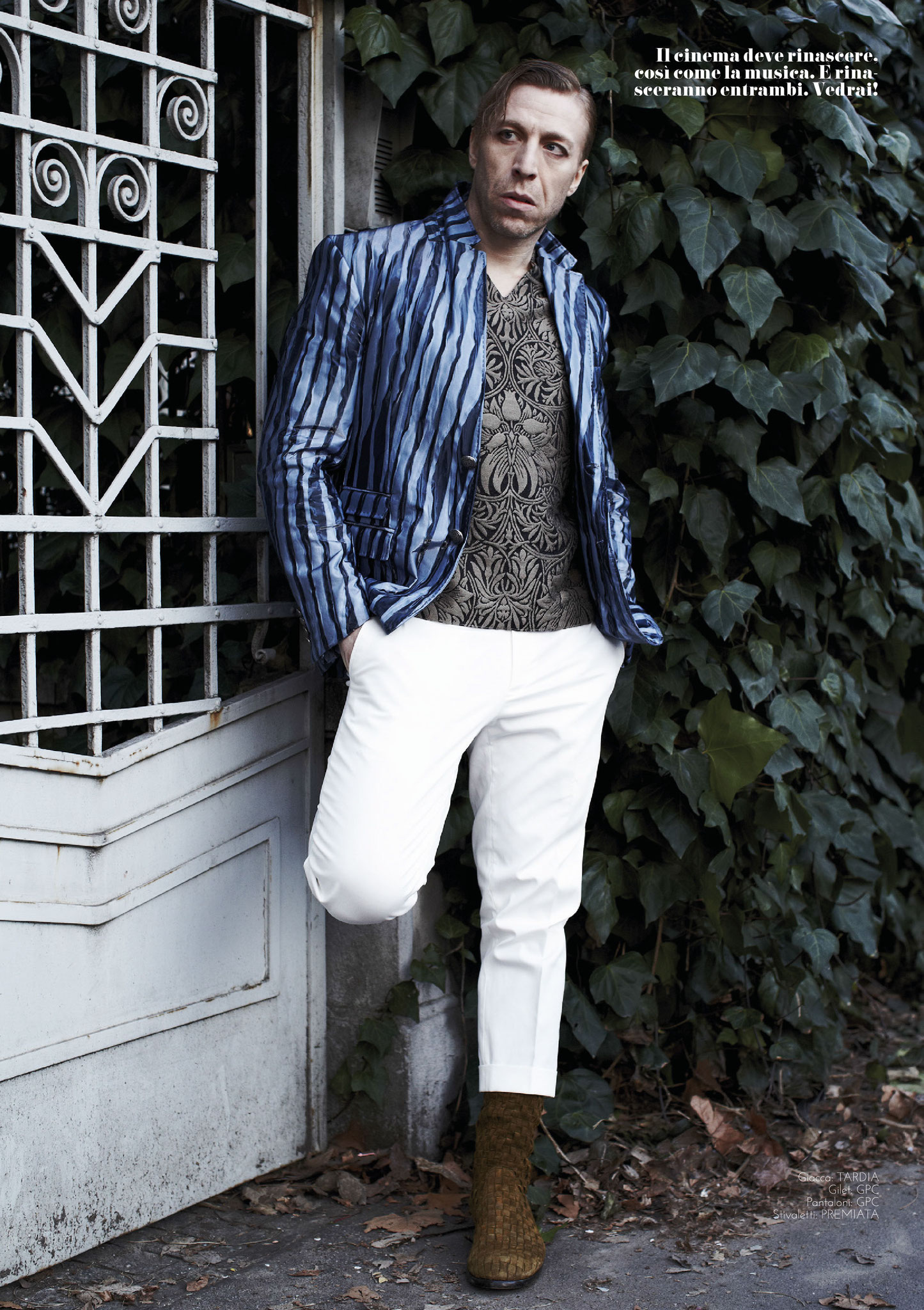 Ottaviano Blitch, Italian actor and performer, glamour fashion portrait in pinstripe shirt and white trousers against dark architecture, attore performer italiano servizio moda glamour