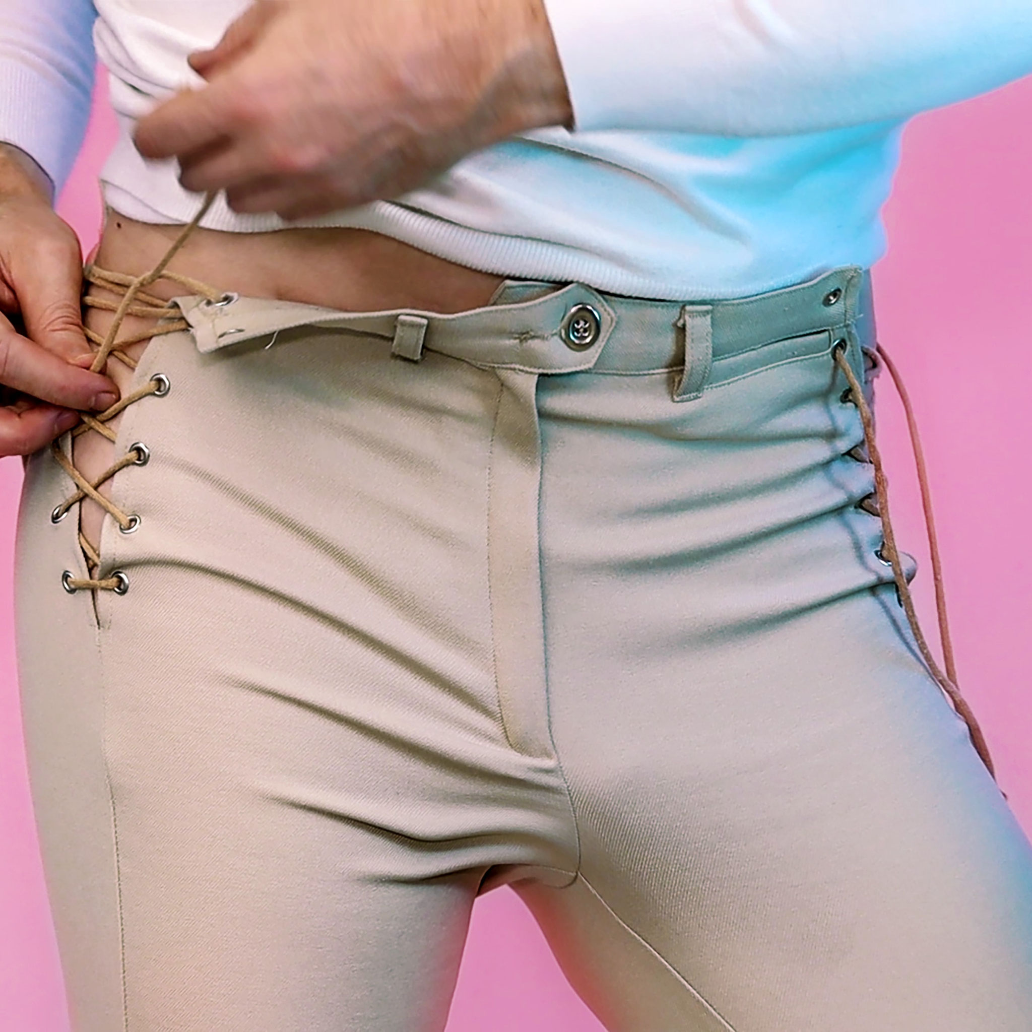 Ottaviano Blitch — dettaglio fashion editoriale, pantaloni con stringhe a occhielli, studio della corporalità in tonalità pastello, actor and model, lace-up trousers fashion detail, body-conscious editorial photography, pink and blue lighting