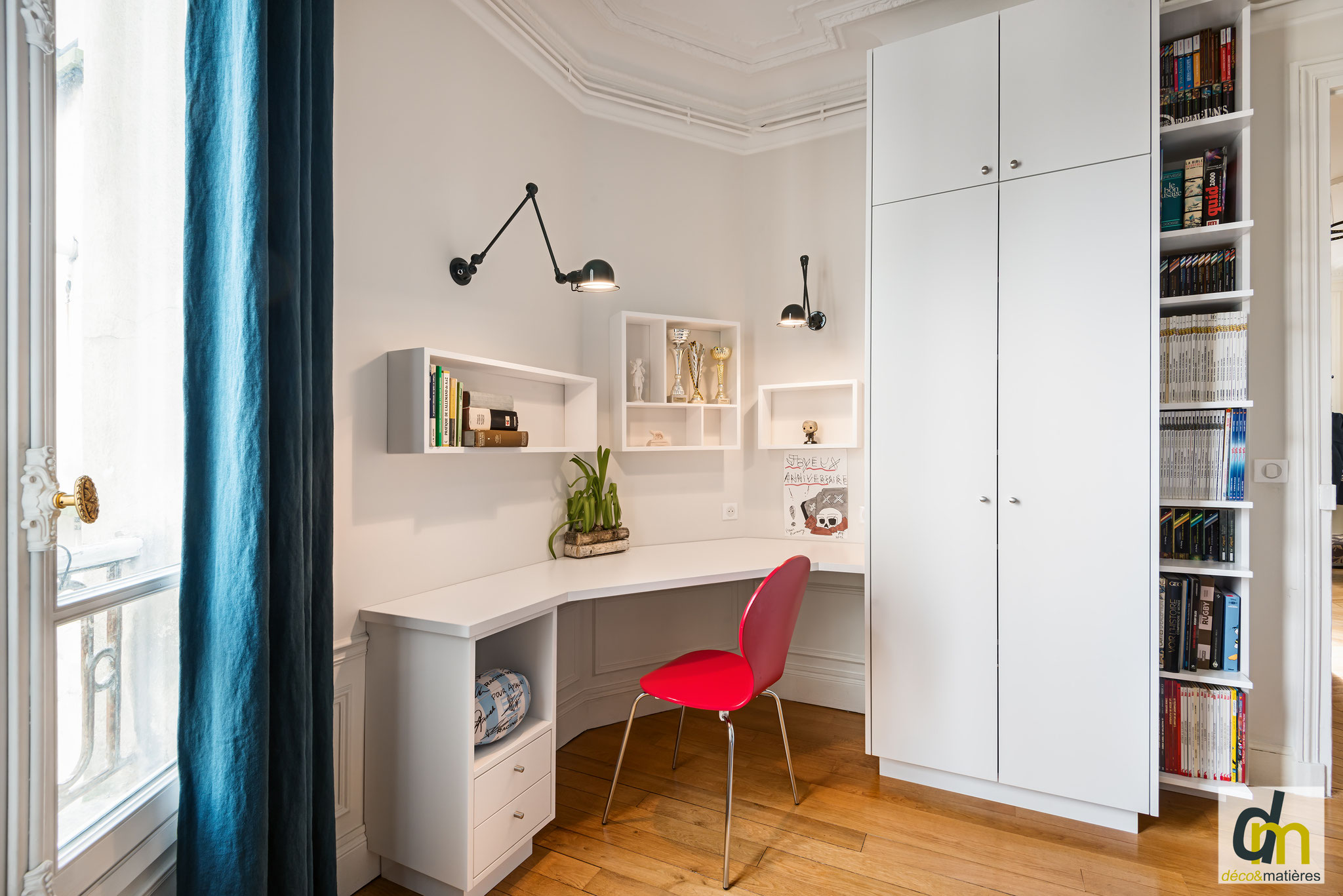 Un bureau sur mesure dans un espace enfant, avec étagères murales, armoire et bibliothèque. Aménagement réussi dans un espace restreint.