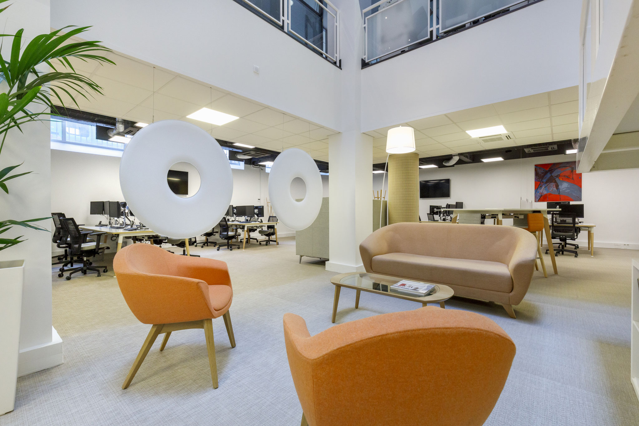 un salon d'accueil dans un espace de co-working, avec du mobilier confortable et contemporain aux couleurs de l'entreprise