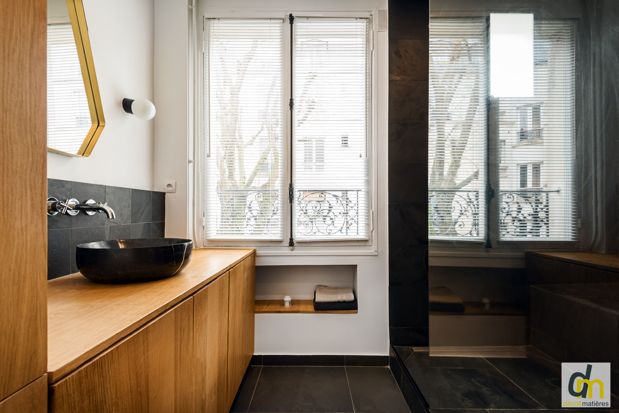 une salle de bain en matériaux naturels : meubles en chêne massif, sol et douche en ardoise véritable, vasque en marbre noir