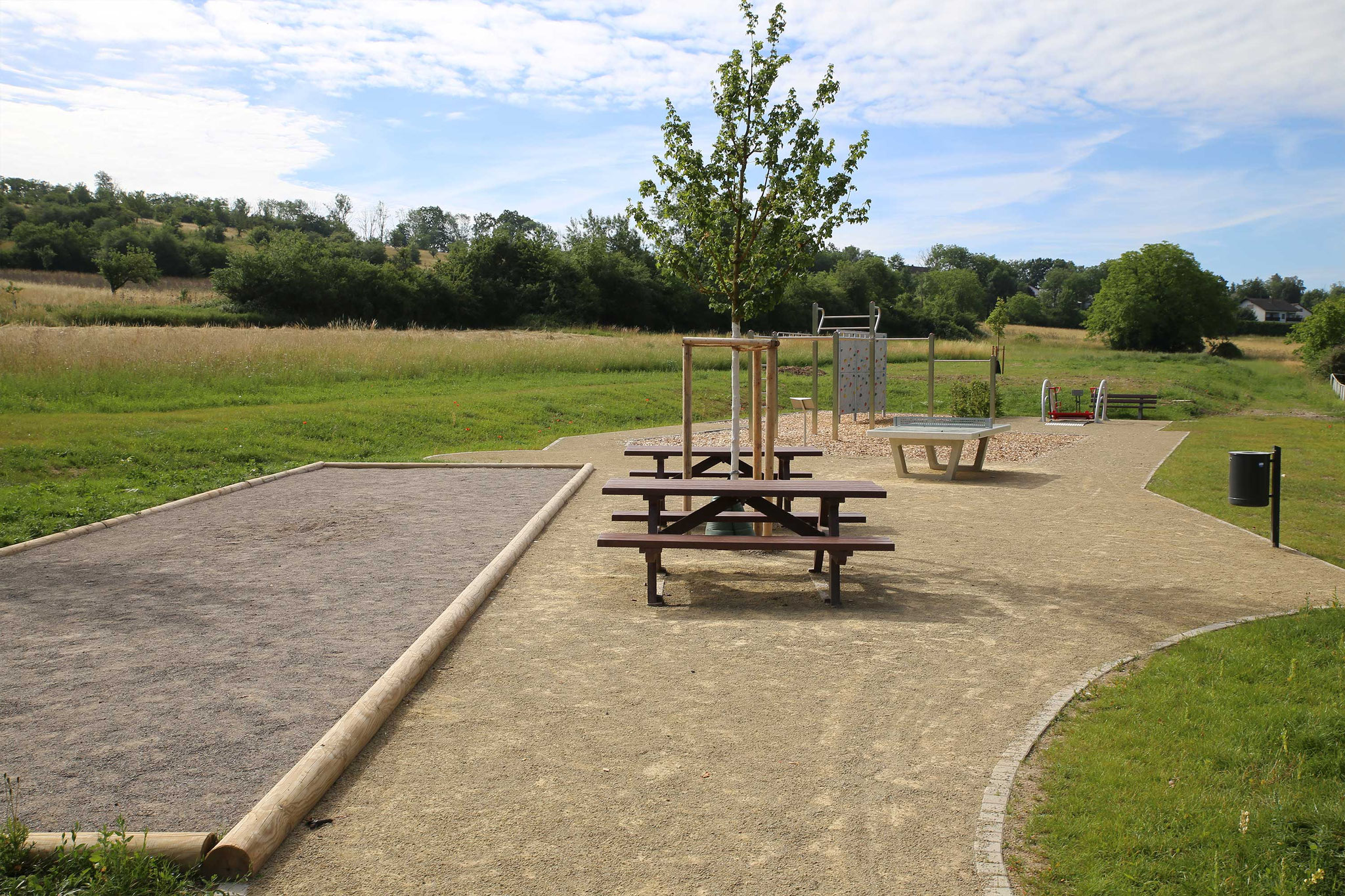 Hinterer Bereich mit Boulebahn, Picknick-Ecke, Tischtennisplatte, Calisthenics, Inklusionsschaukel und Kletterwand