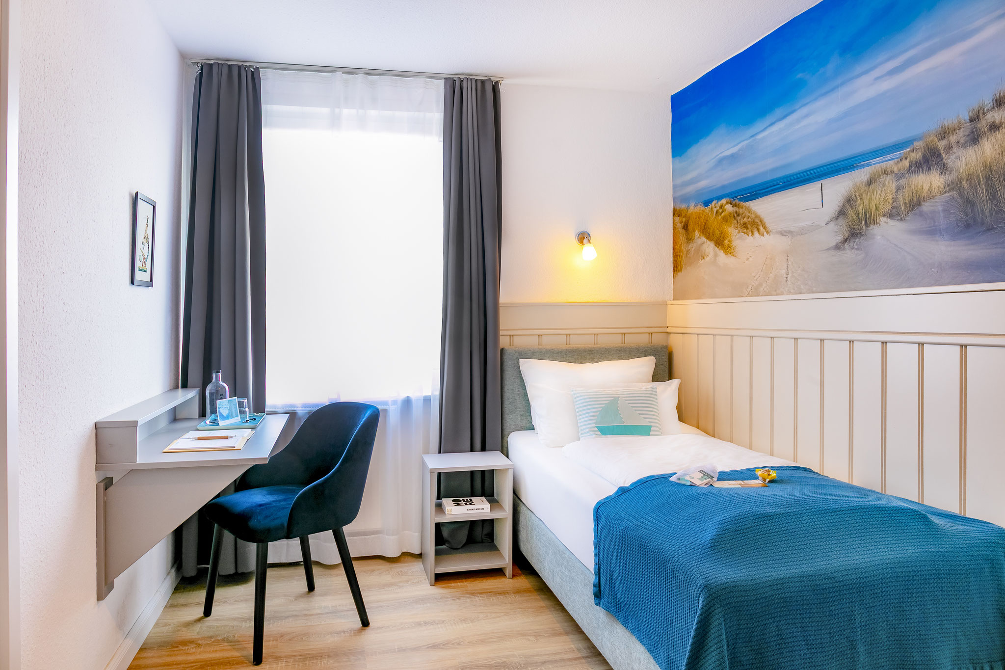 links Schreibtisch, rechts Einzelbett
