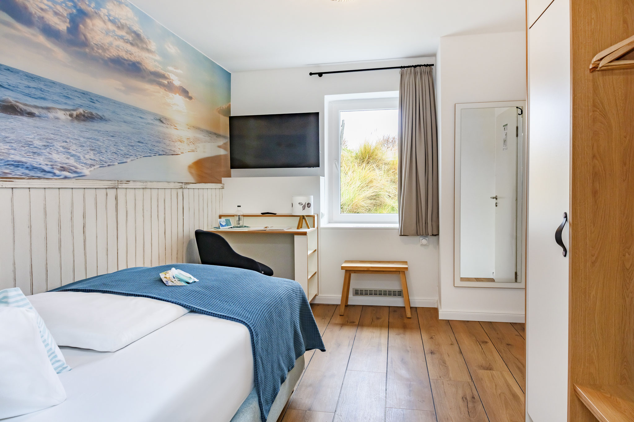 Einzelzimmer mit Bett, TV, Schreibtisch und Schrank