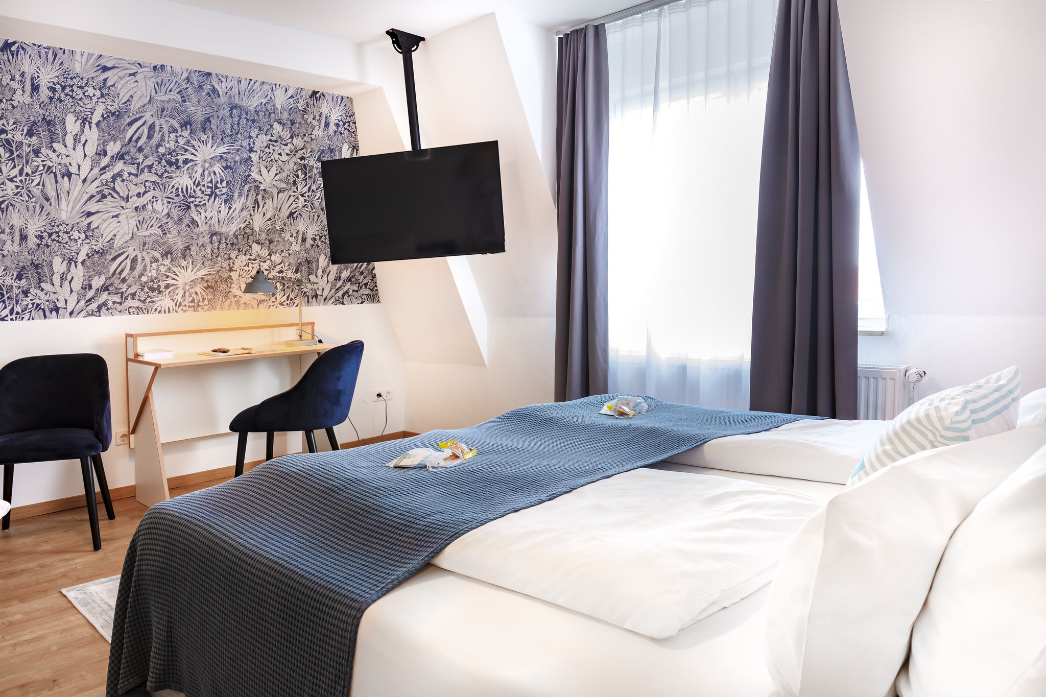 Schreibtisch, Doppelbett und Fernseher