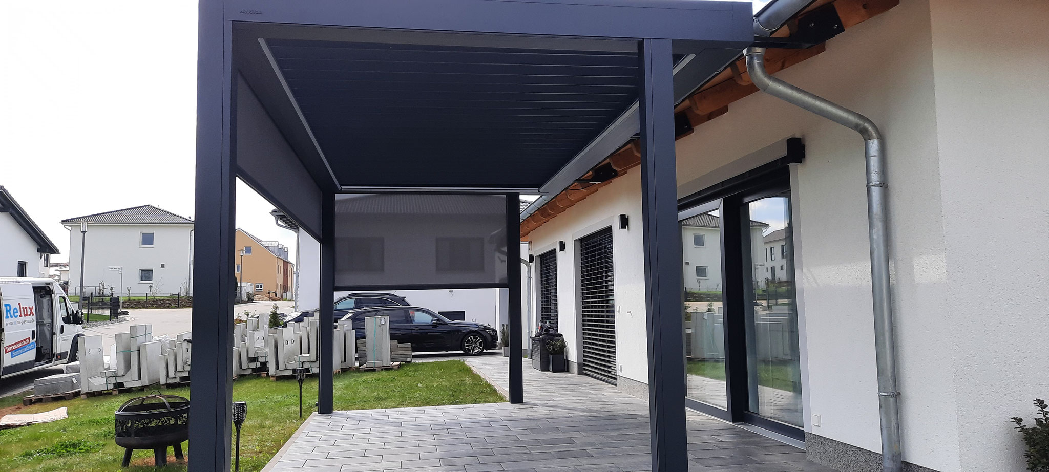 Terrassenüberdachung in anthrazit mit Lamellen freistehend am Haus