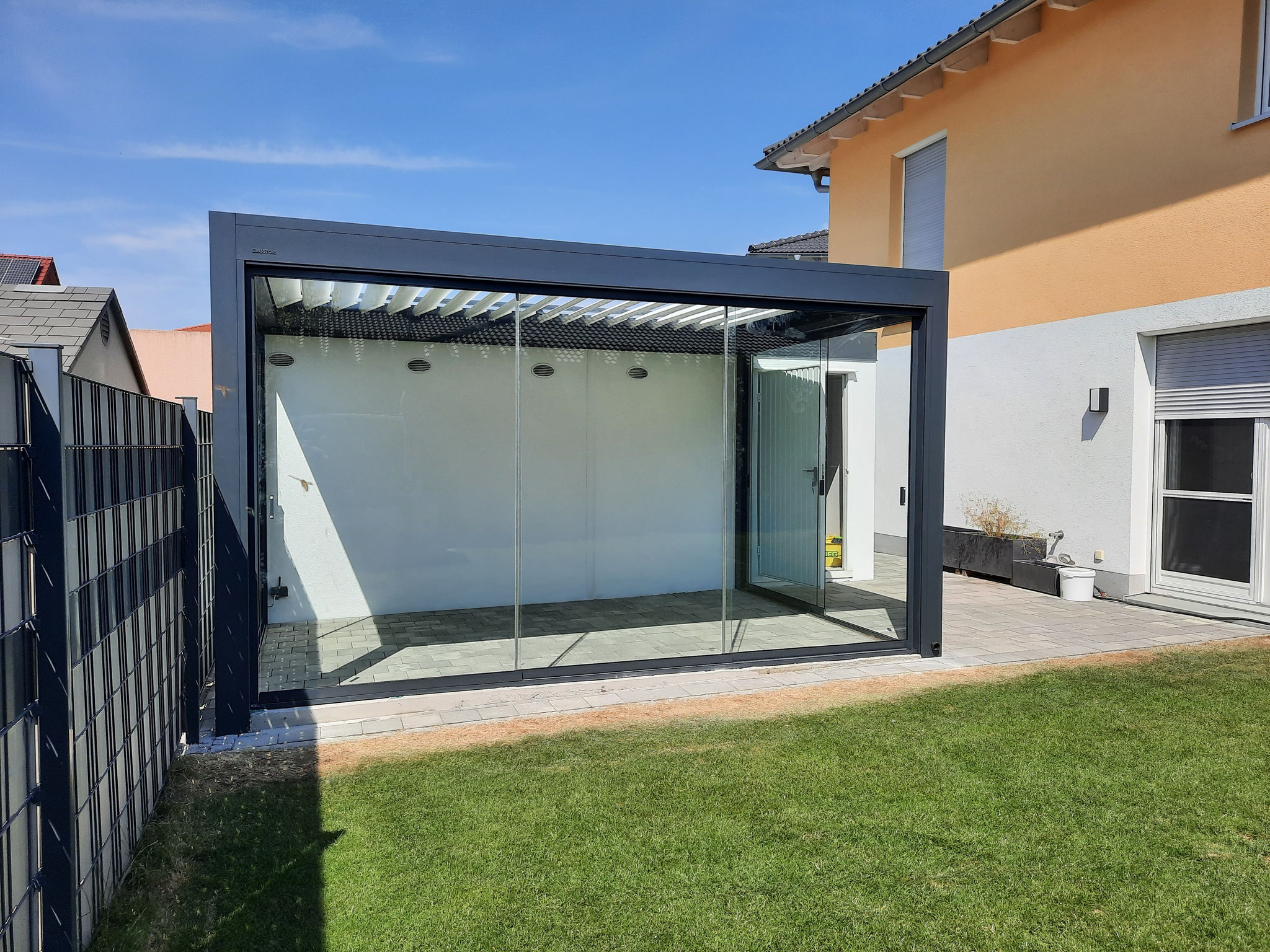 graue Pergola mit weißen Lamellen und Verglasung in Wörth