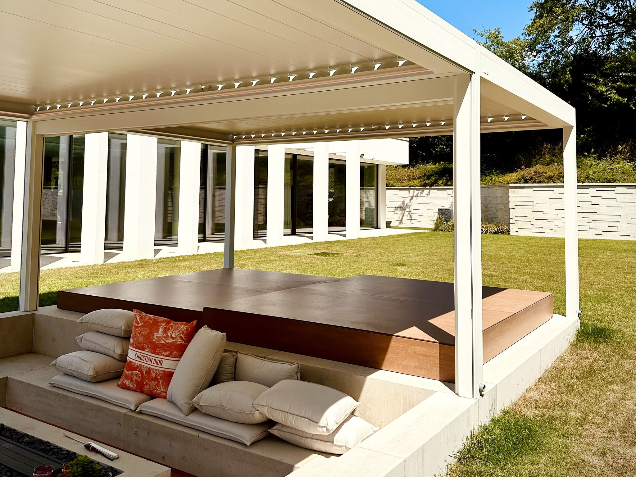 Terrassenüberdachung in weiß mit Lamellen und LED Beleuchtung über Whirlpool